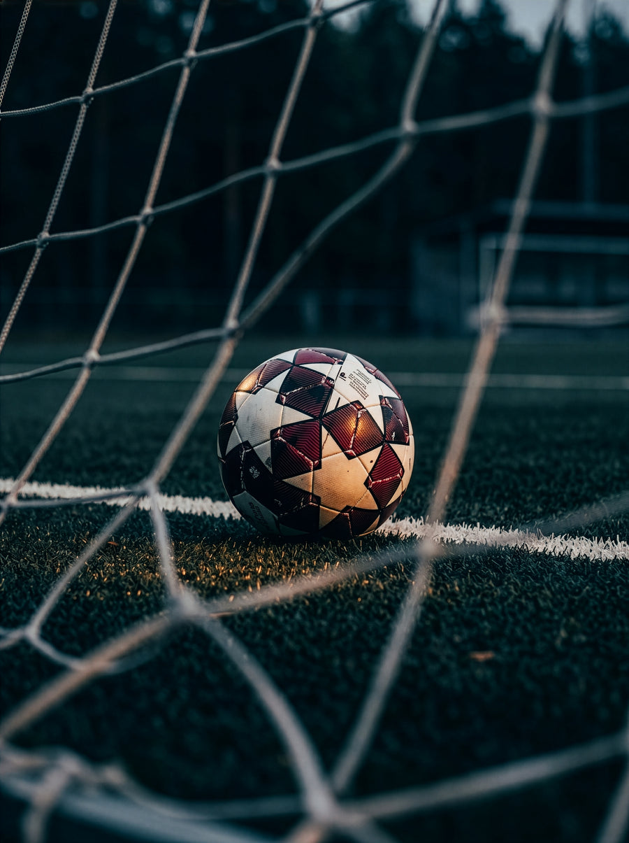 Fußball im Tornetz auf dem Rasen. Schnelle Muskelregeneration für Hobbysportler im aktiven Alltag mit PHAIZE Magnesium Spray.