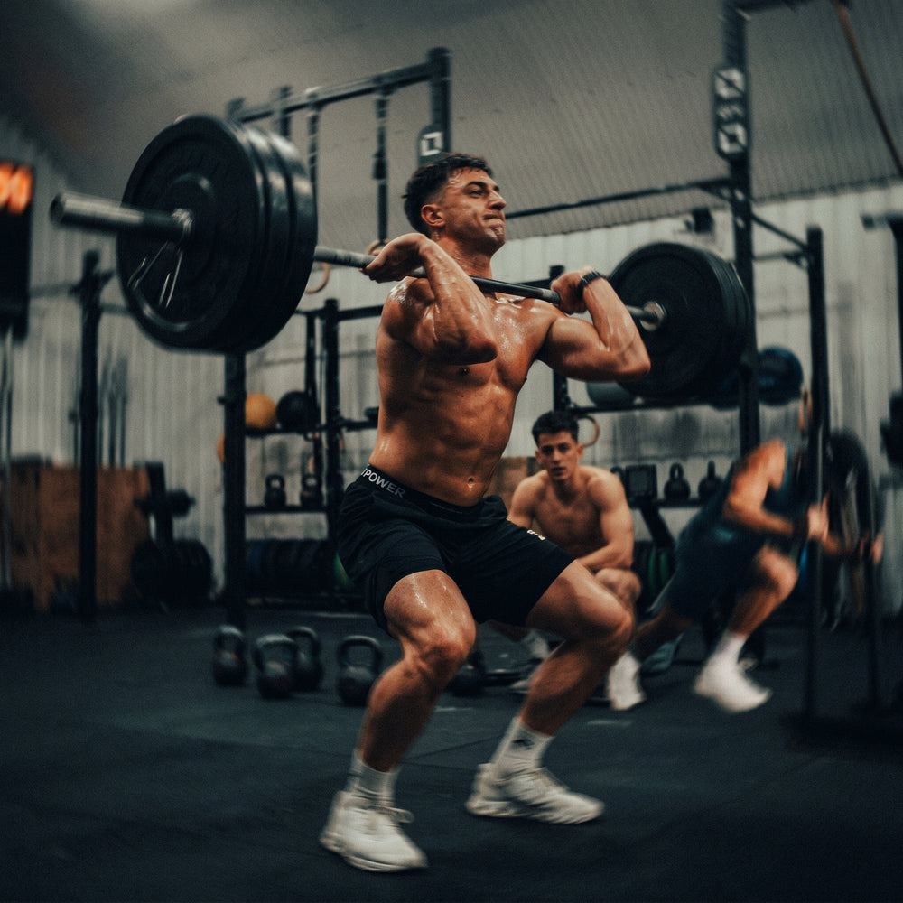 Leistungssportler beim schweren Kniebeugen Workout. Kompromisslose Performance und sofortige Regeneration mit dem PHAIZE Magnesium spray.